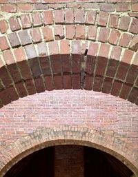 A view of two concentric red brick arches at the ruins of an old estate.