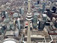 Cityscape looking down on the buildings of downtown Toronto from a helicopter. The CN Tower is centre frame.