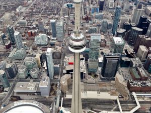 Cityscape looking down on the buildings of downtown Toronto from a helicopter. The CN Tower is centre frame.