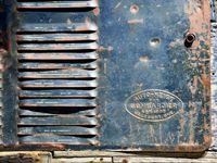 A close-up orthogonal view of the metal side panel of an old snowmobile.