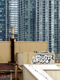 Graffiti can be seen on an old industrial building while high-rise glass condos dominate the background.