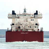 Rear view of a container ship slowly leaving port.