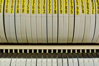 Close-up shot of a row of round data storage tape containers, each with its own bright yello label.