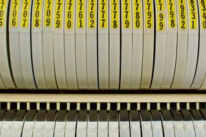 Close-up shot of a row of round data storage tape containers, each with its own bright yello label.