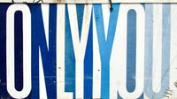 Back alley graffiti depicting block letters that say 'ONLY YOU' in alternating white and blue colors.