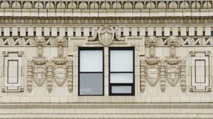An orthogonal view of the top floor of an old building ornately decorated with symmetrical brickwork, borders, crests, and other details.