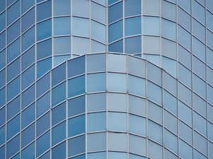 A symmetrical view looking up at the rounded corners of a glass office tower.