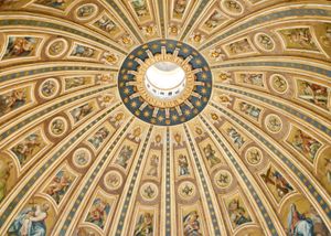 Looking up at the interior of St. Peter's dome. The decorative ceiling radiates dramatically from a circular opening in the upper third of the photo.