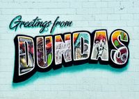 An orthogonal picture of a 'Greetings From Dundas' mural done in a retro travel postcard style on a brick wall.
