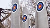 An outdoor art installation made up of airplane wings sticking up in the air with bullseyes painted on their sides.